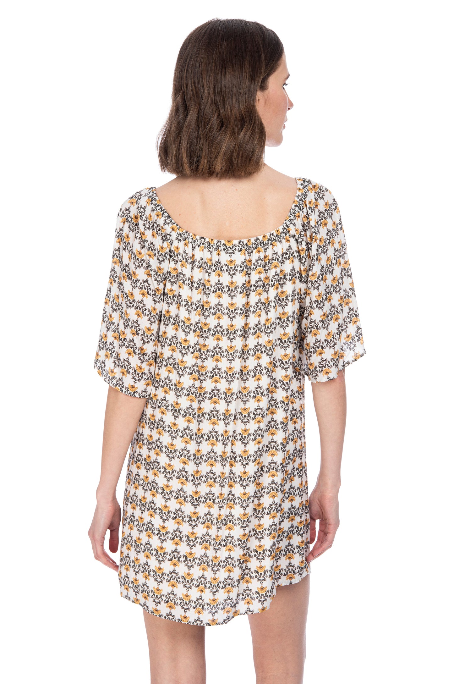 A woman viewed from behind, wearing a versatile dress designed with Rayon Dobby fabric, showcasing an off-shoulder neckline and short sleeves by B Collection by Bobeau ELBOW SLV SHIFT DRESS.