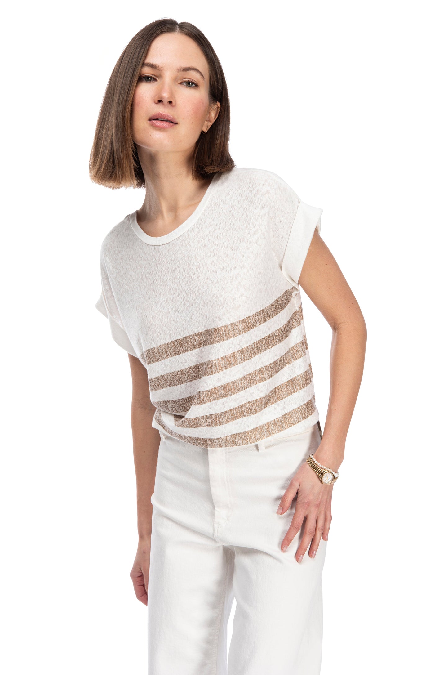 A confident woman in a B Collection by Bobeau CATY STRAP TUNIC TEE paired with white pants, sporting a modern look against a white background.