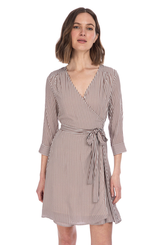 Woman posing in a stylish B Collection by Bobeau WILLA STRIPE WRAP DRESS with a v-neckline and three-quarter sleeves, fully lined.