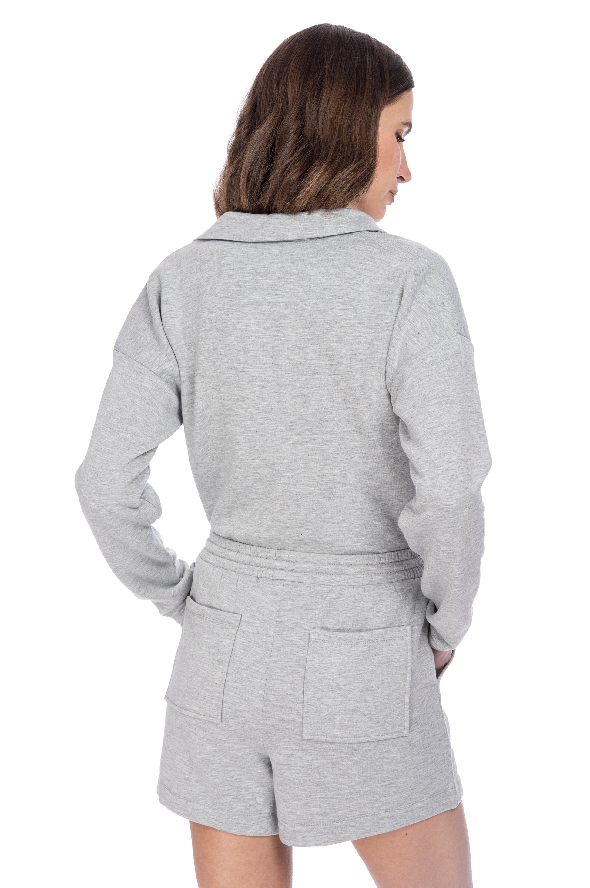 A woman seen from the back, wearing a casual gray B Collection by Bobeau FLEECE COLLAR TOP & SHORT SET, posing against a white background.