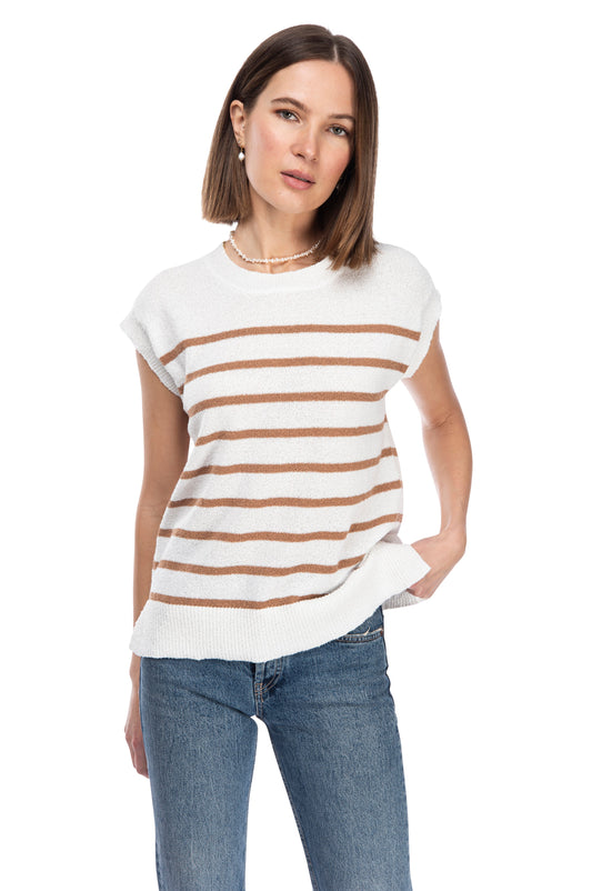A woman in a casual pose wearing a white and brown striped B Collection by Bobeau crew neck sweater top with blue jeans against a white background.