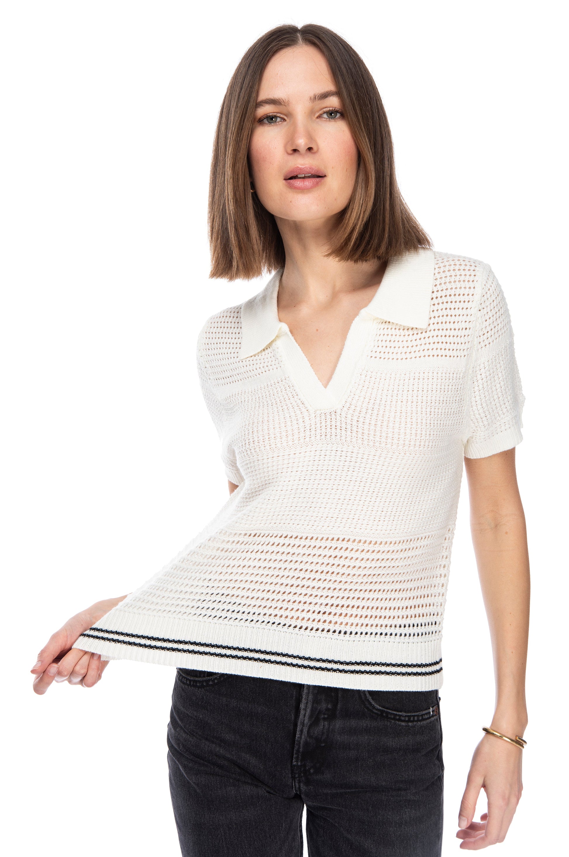 Woman showcasing a B Collection by Bobeau white acrylic knit POLO OPEN WEAVE SWEATER with collar detail, paired with black jeans, against a white background.