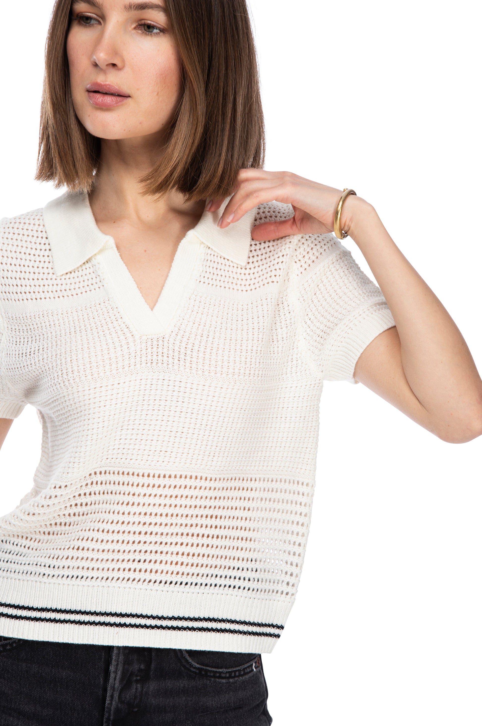 A woman in a white POLO OPEN WEAVE SWEATER top with a collar poses confidently, her hand resting on her shoulder.