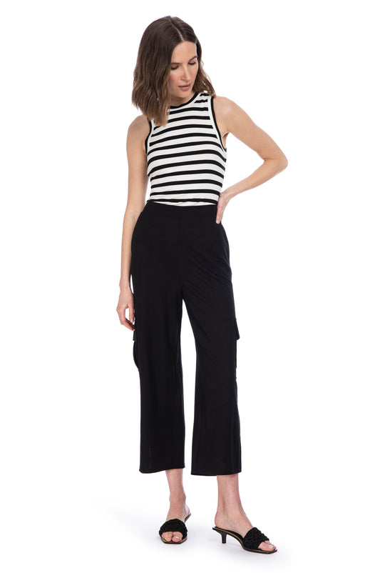 A woman posing in a chic black and white striped sleeveless top, paired with elegant B Collection by Bobeau SIDE SLIT CARGO PANTS featuring an elastic waist and stylish black heeled sandals.