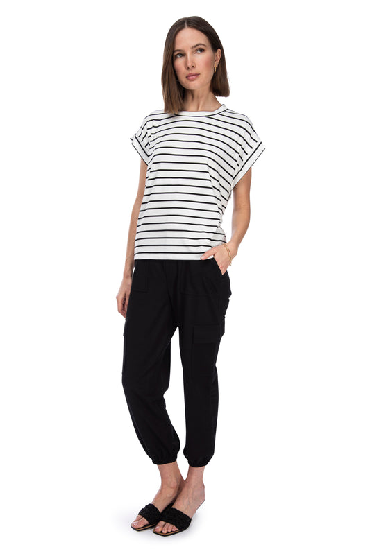 A woman posing in a casual outfit, featuring a striped short-sleeved knit pique top and black B Collection by Bobeau cargo pants with an elastic waist, paired with simple black sandals.