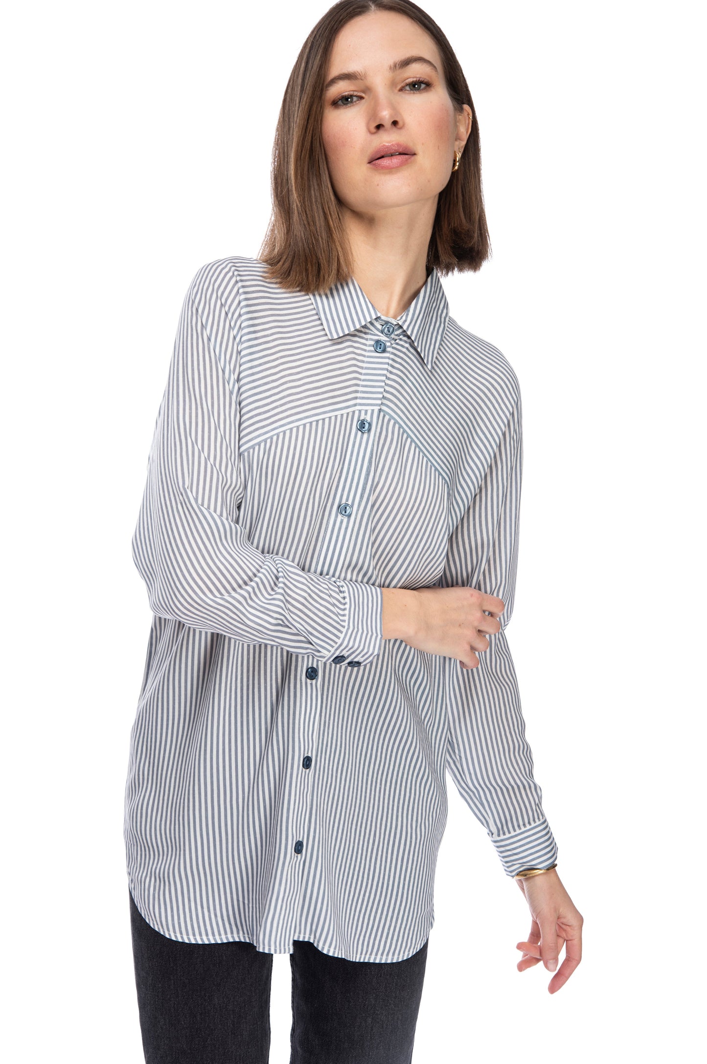 A woman standing confidently, wearing a casual striped rayon LS BTTN DOWN TUNIC with a lapel collar and jeans by B Collection by Bobeau.